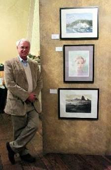 杰夫·沃特斯站在他的三幅珍贵的水彩画旁边.